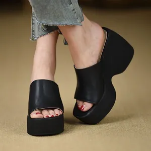 Primo piano dettagliato di sandali neri con zeppa e plateau indossati con jeans in denim