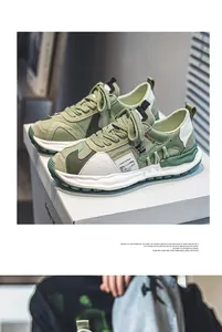 Detailed side view of green and white breathable chunky low-top outdoor sneakers for men