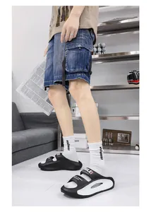 Side view of black and white EVA sports slides with "SMILE" print on a male model.