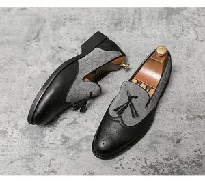 Detalle de mocasines Brogue para hombre con tela de espiga gris y borlas de cuero negro