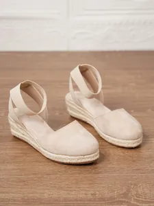 Vista lateral de sandalias de cuña esparteñas beige para mujer con suela de paja