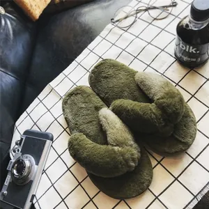 Nahaufnahme der olivgrünen flauschigen Pelz-Flip-Flop-Hausschuhe mit Plateausohle.