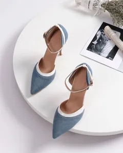 Close-up detail of stylish blue denim pointed-toe slingback heels with white trim