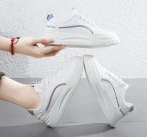 Λεπτομερής προβολή λευκών sneakers με χοντρή σόλα και κεντημένες λεπτομέρειες Smile.