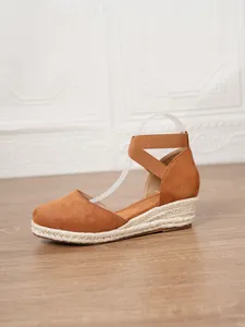 Vista lateral de sandalias de cuña tipo alpargata con tiras elásticas cruzadas en tobillo
