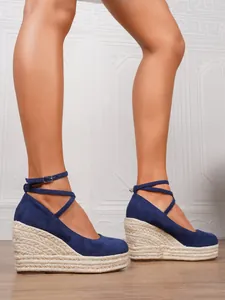 Sandalias de cuña alpargata azules de gamuza con punta cerrada y correa al tobillo.
