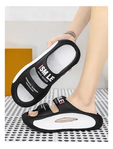 Close-up view of stylish black and white EVA slides featuring Smile and Super text prints.