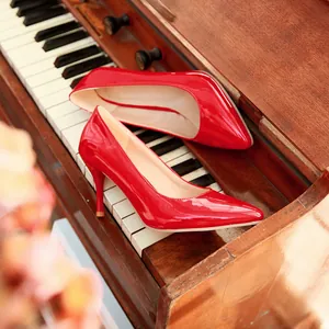 Élégants escarpins à talons aiguilles rouges pointus sur un clavier de piano en bois.