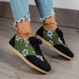 Close-up view of stylish floral print sneakers for women on a rustic wooden floor setting