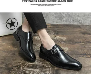 Close-up of black monk strap dress shoes with brogue detailing and buckle.