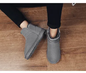 Macro view of stylish grey suede snow boots with buckle detail on rustic wooden floor background