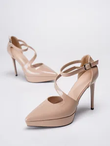 Nahaufnahme von nackten Lackleder-High-Heels mit spitzer Zehe und Knöchelriemen