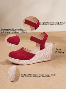 Vista detallada de sandalias con cuña rojas con detalles de paja y tira elástica