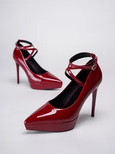Elegantes salones rojos con plataforma de charol, punta estrecha y tacones de aguja.