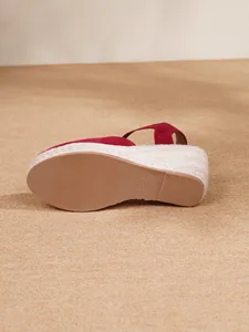 Vista detallada de la suela de sandalias de cuña rojas con plataforma de cuerda y paja