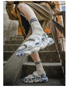 Close-up of trendy men's graffiti sandals with thick soles worn on concrete stairs