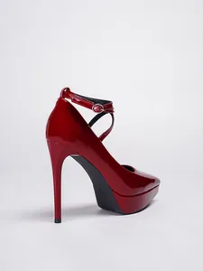 Vista trasera de tacones de aguja en charol rojo con plataforma y correa al tobillo