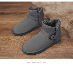 Close-up detail of grey suede snow boots with thick warm fur lining and side buckle