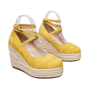 Elegantes sandalias de cuña amarillas con punta cerrada y plataforma de esparto.