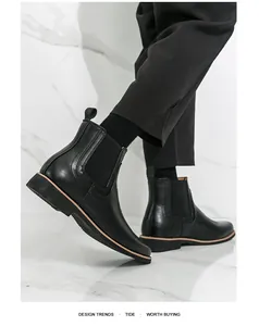 Detailansicht von schwarzen Brogue-Chelsea-Boots aus Leder, am Modell getragen.