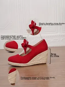 Detalle de sandalias de cuña rojas con tacón de esparto de 8 cm y correa con lazo