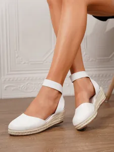 Alpargatas blancas con cuña para mujer, mostradas en pies en un ambiente interior