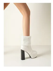 Detailed view of white platform ankle boots with sherpa cuff and chunky black heels