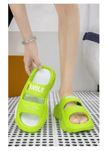 Close-up view of lime green EVA platform sandals with decorative 'SMILE' text printing.