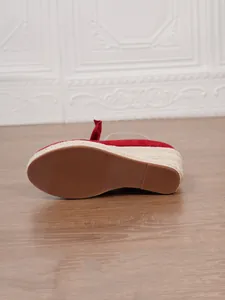 Detalle de la suela antideslizante y cuña de esparto en sandalias rojas