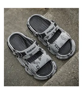Grey men's chunky sports sandals with 'FASHION' strap on an urban concrete stair