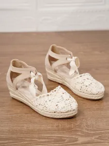 Vista detallada de las sandalias de cuña tipo alpargata con encaje de ganchillo en color beige