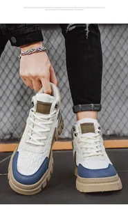 Gros plan sur des bottes blanches pour hommes avec des accents bleus et semelles beiges