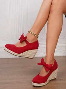 Elegantes sandalias rojas de cuña para mujer con tiras de lazo y suelas de paja tejida
