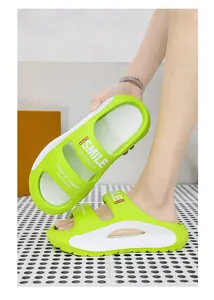 Detail view of stylish lime green EVA platform slides featuring a unique SMILE print design