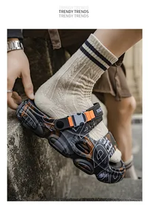 Close-up of stylish men's platform sandals with orange buckle and graffiti print