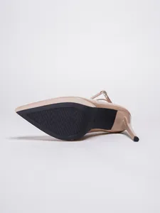 Vista detallada de la suela antideslizante negra en un elegante tacón de aguja beige