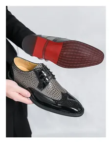 Nahaufnahme von zweifarbigen Herren-Brogue-Schuhen mit Krokostruktur und roter Sohle