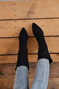 Draufsicht auf stylische schwarze spitze elastische Halbstiefel mit Jeans.