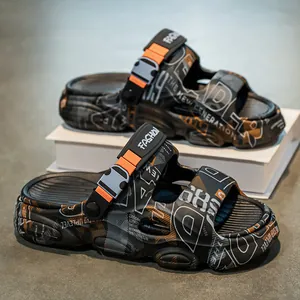 Trendy men's thick-soled black slides with graffiti patterns and orange strap accents