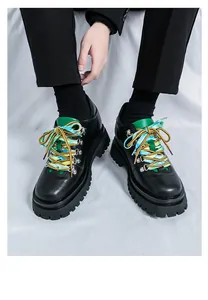 Primo piano di scarpe stringate in pelle nera da uomo con lacci colorati e suola spessa.