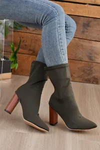 Olivegrüne spitze Stretch-Stiefeletten mit klobigem Absatz in Holzoptik am Modell.