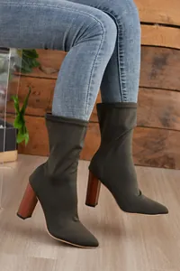 Nahaufnahme von olivgrünen Stretch-Stiefeletten mit klobigem Absatz in Holzoptik