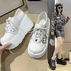 Nahaufnahme weißer Gothic-Plateau-Sneaker mit Herzschnalle und metallischen Schnürdetails.