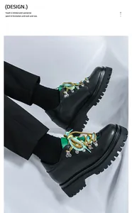 Dettaglio di scarpe in pelle nera con plateau, lacci colorati e occhielli argentati