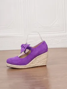 Elegantes alpargatas de cuña en gamuza violeta con plataforma de cuerda y detalle de lazo