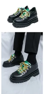 Vista dettagliata di scarpe in pelle nera da uomo con lacci colorati e suola spessa.