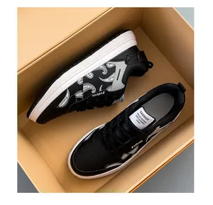 Detailed view of black leather skateboard shoes with white paisley patterns in a box