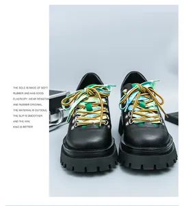 Vista frontale di scarpe platform nere con vivaci lacci colorati verdi e gialli