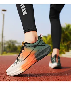 Primer plano de zapatillas de correr transpirables degradadas naranja y verde en pista