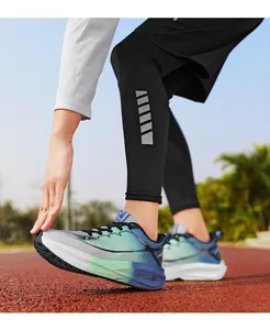 Primer plano de zapatillas deportivas con degradado azul y verde en pista con suelas gruesas.